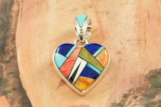 Genuine Turquoise, Spiny Oyster Shell, Magnesite, Blue Lapis and Black Jade inlaid in  Sterling Silver. Precision inlay on the bale and pendant. Free 18" Sterling Silver Chain with Purchase of Pendant. Beautiful Heart Pendant Designed by Navajo Artist Calvin Begay. Signed. 